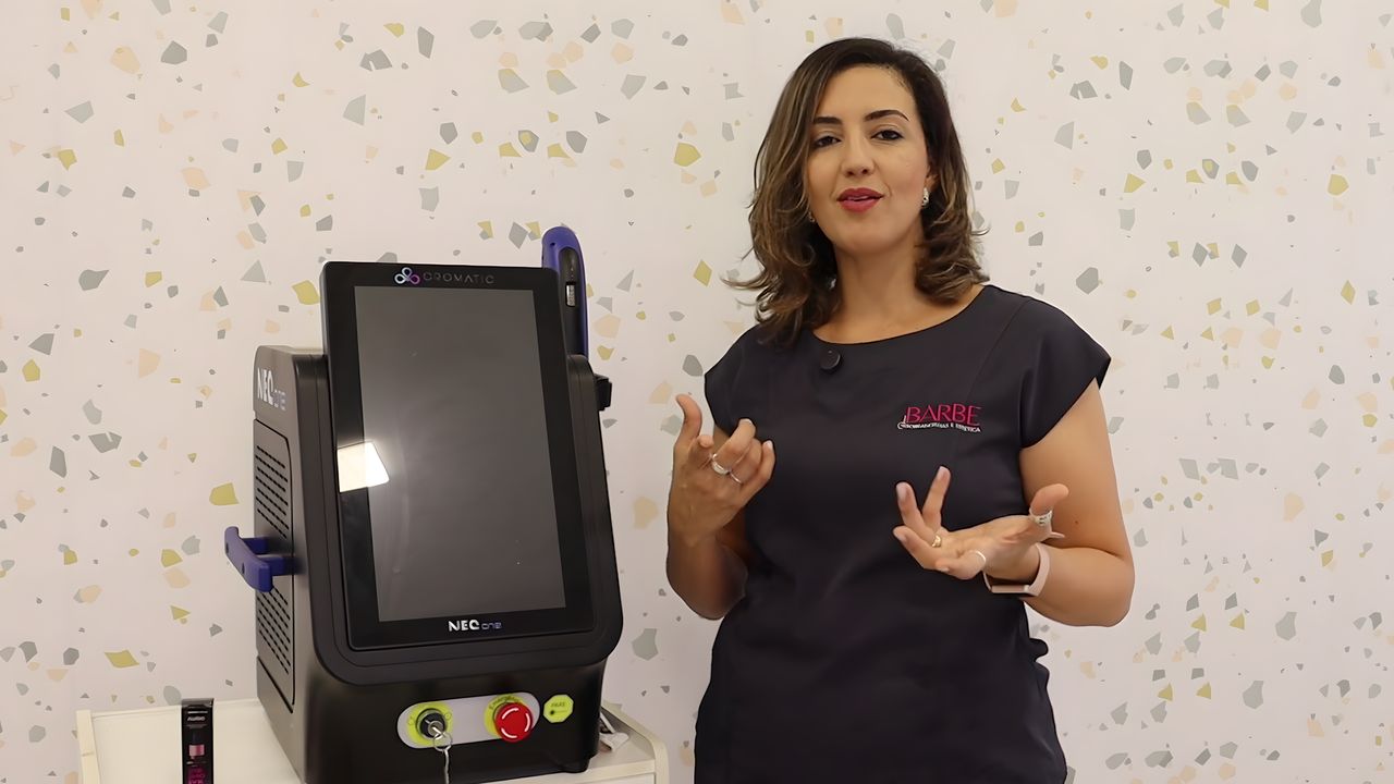 Dani Barbe ao lado do equipamento de laser em uma aula