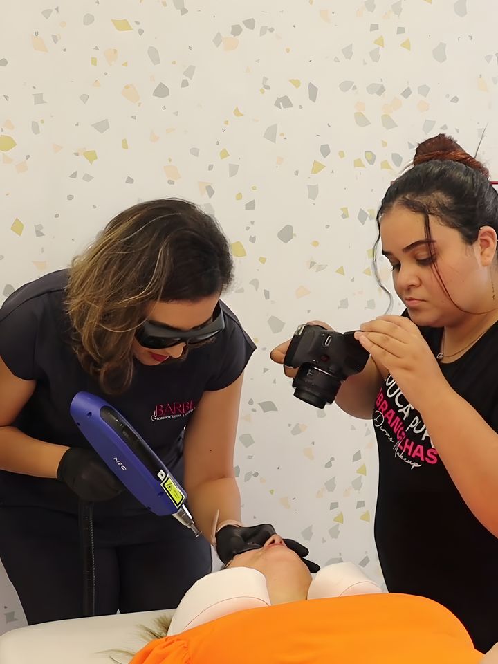 Dani Barbe faz a remoção a laser enquanto outra profissional registra o atendimento